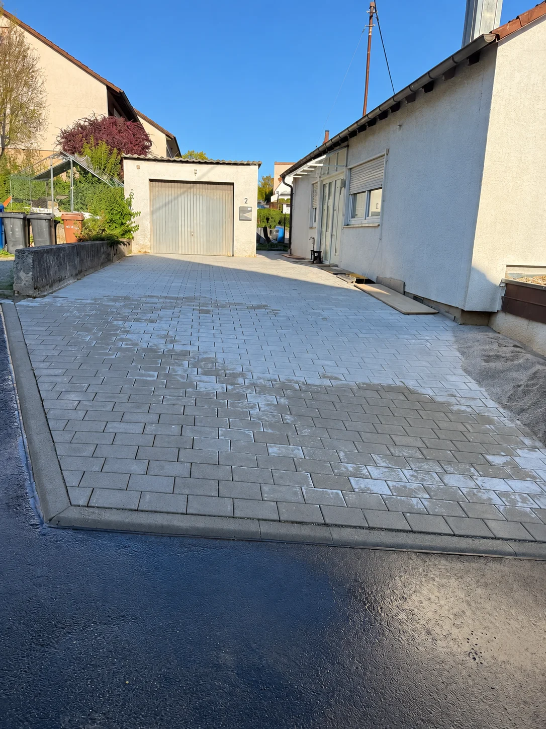 Pflasterfläche zwischen Wohnhaus und Garage.