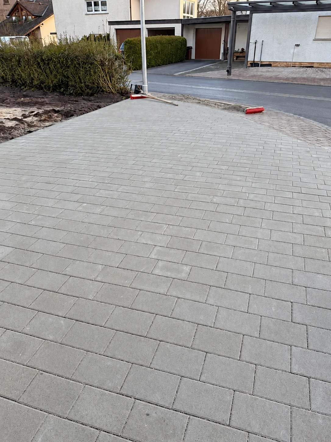 Pflasterfläche mit geschwungenem Anschluss zur Straße.